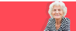 Older woman smiling in front of a red background