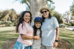 Image of two women smiling with a child wearing a bike helmet
