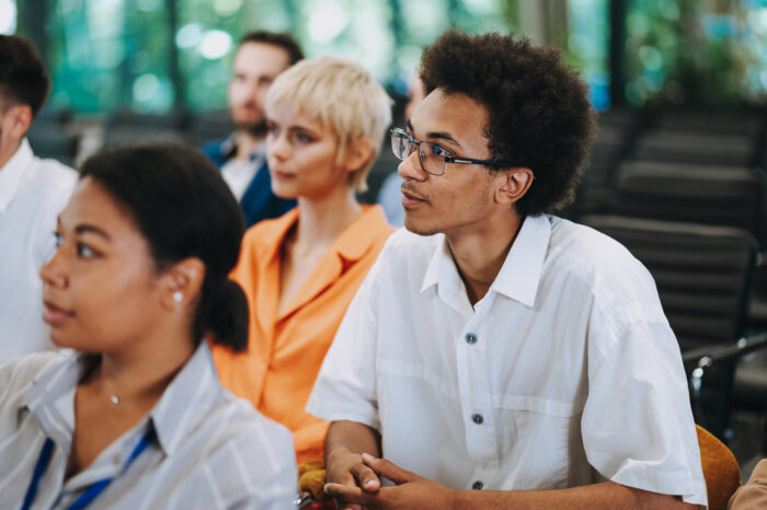 Cinematic image of a conference meeting. Business people sitting in a room listening to the motivator coach. Representation of a Self growth and improvement special event